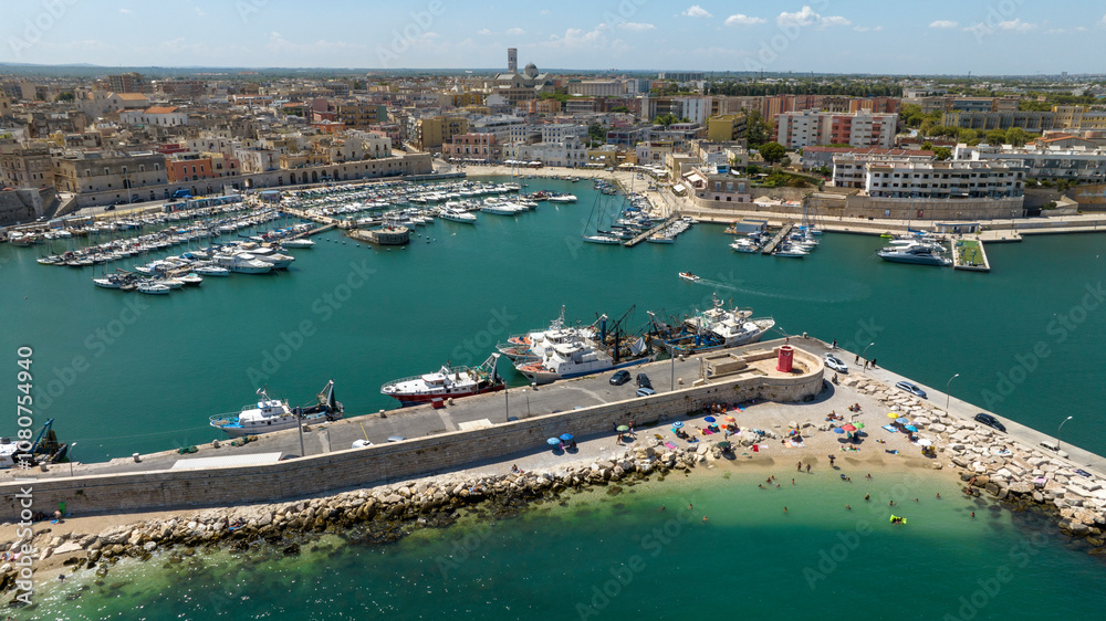 Fototapeta premium Aerial view of the port of Bisceglie, in Puglia, Italy. It is a small marina with many boats anchored located on the Mediterranean Sea.