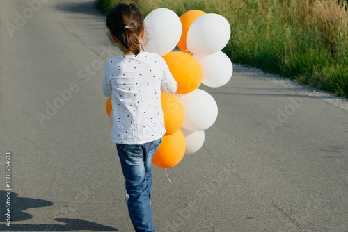 Girl carrying bunch of balloons