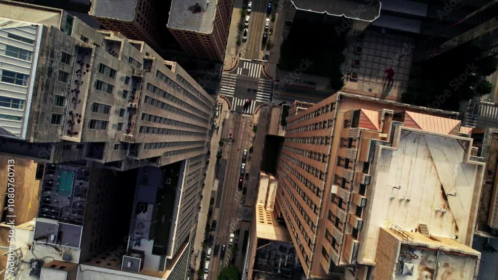 The drone flies over the roofs of the skyscrapers of an American city. Cars drive through the streets between the houses The drone flies over the roofs of the skyscrapers of an American city. Cars drive through the streets between the houses