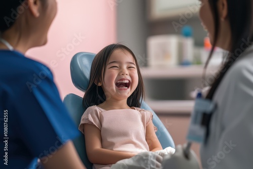 Laughing Japanese girl at dentist with mother, early dental checkup