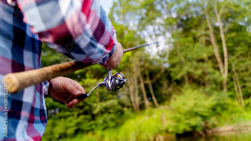 Obraz na plátne a fisherman with a spinning rod catches fish from a boat