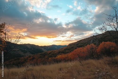 Autumn sunset over mountains, vibrant orange foliage, dramatic clouds, serene landscape