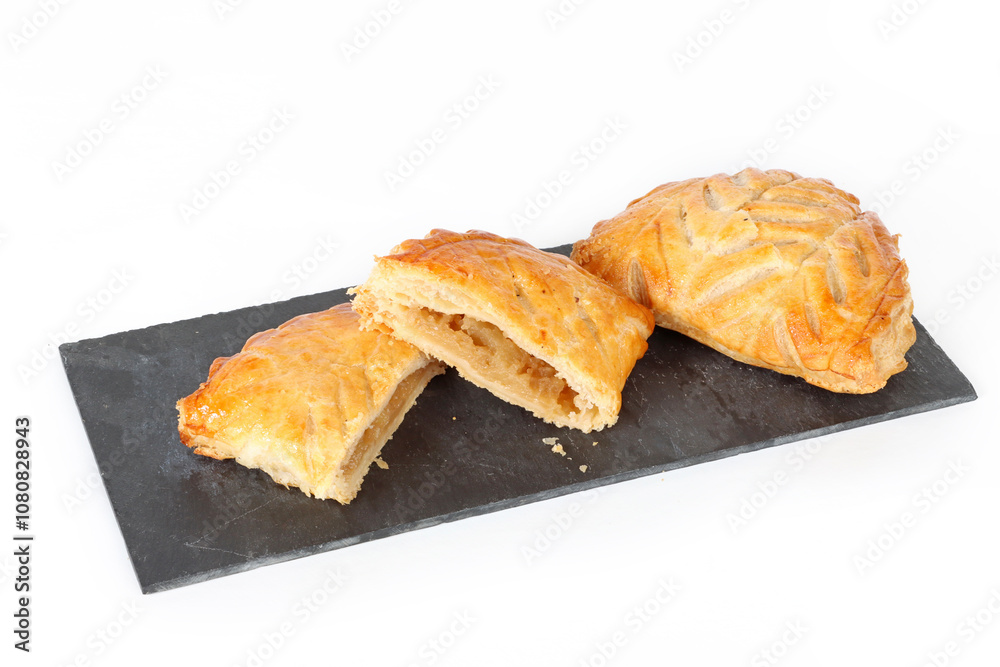 French apple turnovers displayed on a slate board in a studio setting French apple turnovers displayed on a slate board in a studio setting