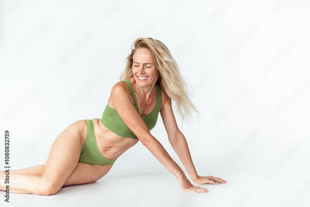 Photo of gorgeous mature blonde lady posing sit floor wear khaki lingerie isolated white background no retouch Photo of gorgeous mature blonde lady posing sit floor wear khaki lingerie isolated white background no retouch