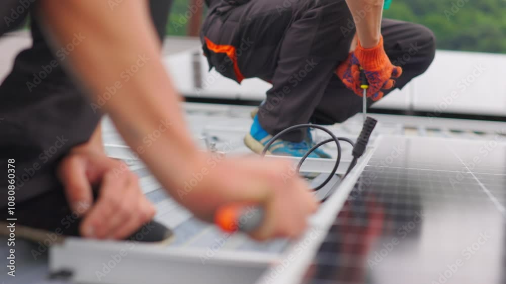 Installation, Connection and mounting of solar panels. Two workers fasten solar panels. Technicians installing solar panels on metal stand. Workers installing PV solar panels on the roof of a house.