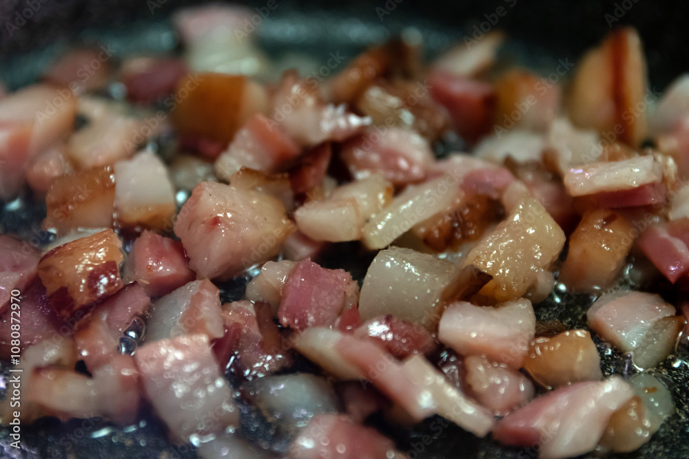 Sizzling diced bacon cooking in a skillet, perfect for adding flavor to various dishes in your kitchen. Sizzling diced bacon cooking in a skillet, perfect for adding flavor to various dishes in your kitchen.