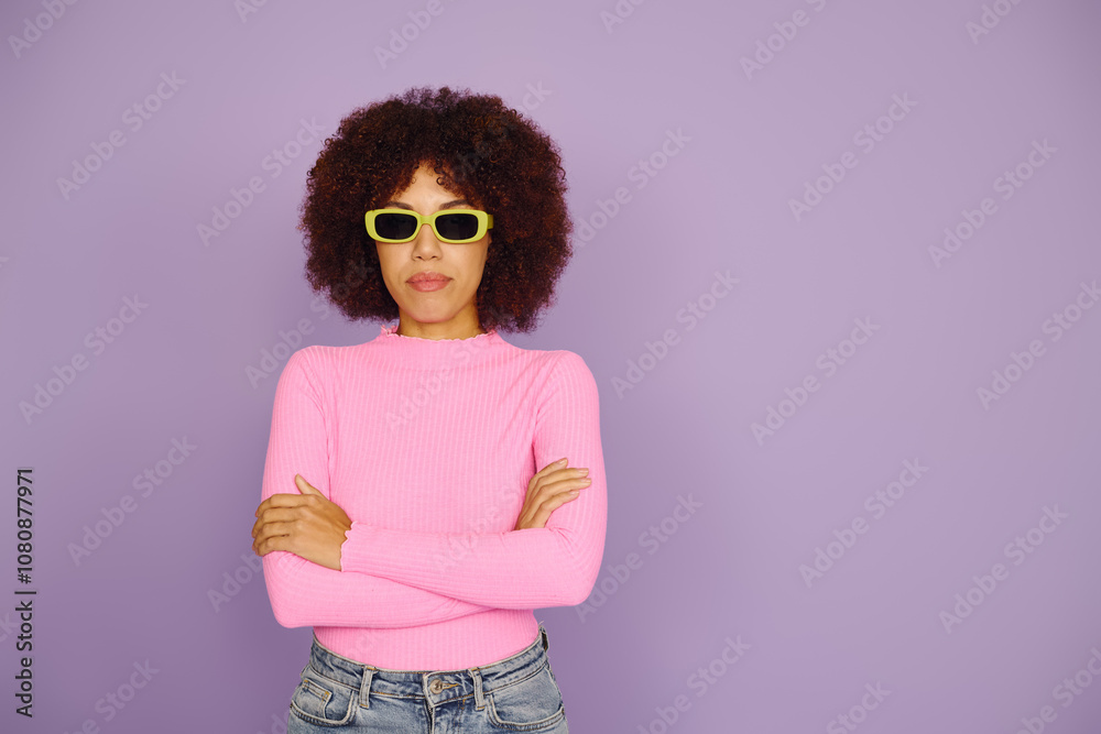 A young African American woman in casual pink clothing displays strong emotions with a vibrant backdrop. A young African American woman in casual pink clothing displays strong emotions with a vibrant backdrop.