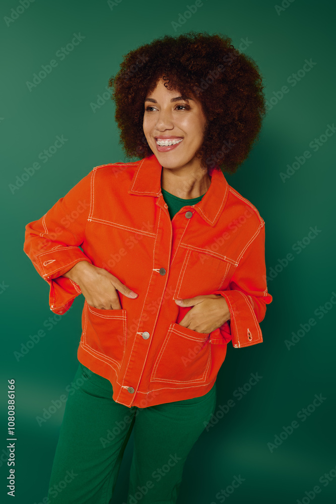 A young woman with curly hair beams brightly in casual clothing, radiating happiness on a lively green background. A young woman with curly hair beams brightly in casual clothing, radiating happiness on a lively green background.