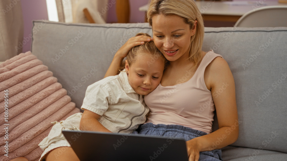 Mother and daughter sitting together on a couch in a cozy living room, sharing a tender moment while looking at a laptop screen. Mother and daughter sitting together on a couch in a cozy living room, sharing a tender moment while looking at a laptop screen.
