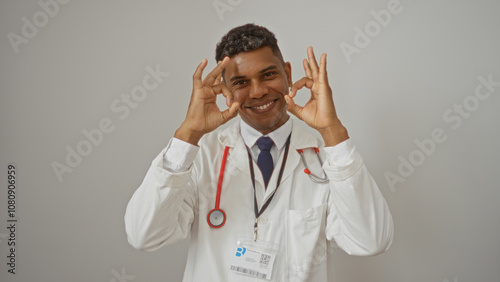 Doctor making ok gesture on white background, showcasing confidence and positivity.