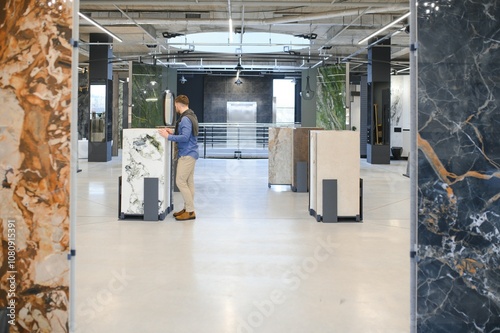 Man chooses wall tiles for the bathroom in the supermarket building materials