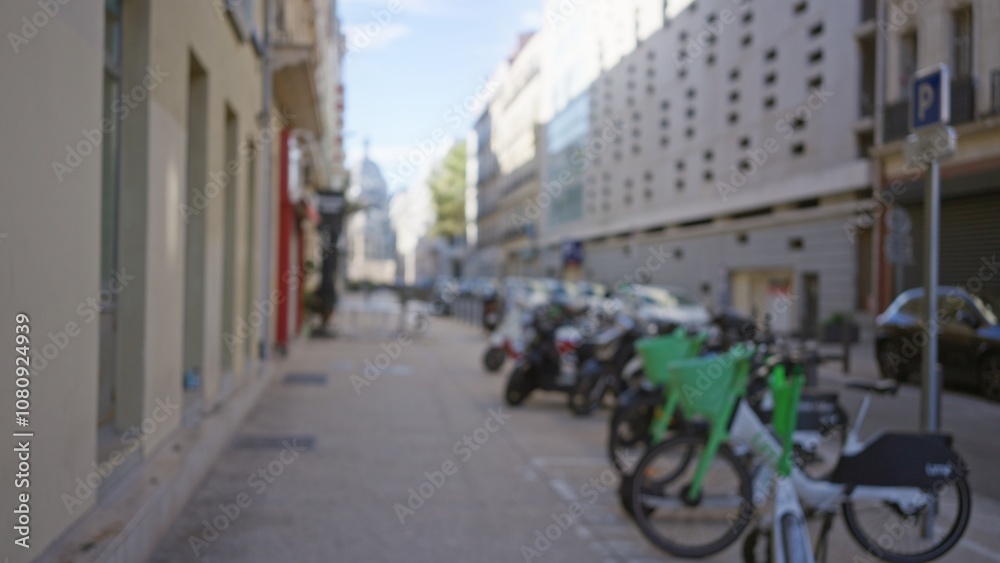 Blurred view of an outdoor street scene in marseilles, france, featuring parked bicycles and scooters with urban buildings in the background under a clear sky. Blurred view of an outdoor street scene in marseilles, france, featuring parked bicycles and scooters with urban buildings in the background under a clear sky.