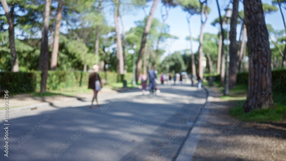 Blurred people walking in villa borghese gardens in rome with lush trees and sunshine, capturing serene outdoor vibes with defocused background and subtle bokeh effect. Blurred people walking in villa borghese gardens in rome with lush trees and sunshine, capturing serene outdoor vibes with defocused background and subtle bokeh effect.