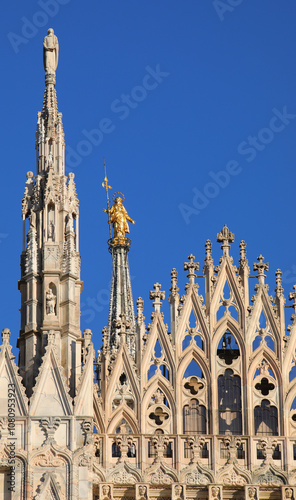 statue of the holy Virgin Mary called the Madonnina is located among the tall spires of the Gothic Duomo of Milan in Northern Italy