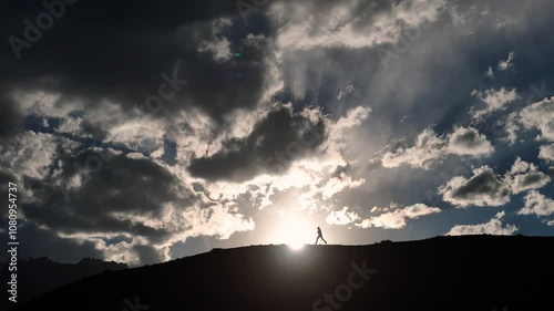 Aerial Drone shot, silhouette man running on the top of the mountain.  photo