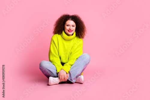 Full size photo of pretty young girl sit floor crossed legs wear trendy yellow outfit isolated on pink color background