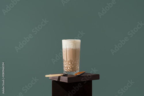 Glass of coffee with milk and brown sugar on wooden surface photo