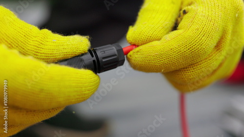 An electrician checks the wires. Special wire hardener at the power plant. An electrician in protective gloves installs wires. Connection of soy panels. photo