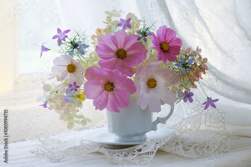 Bouquet of cosmos flowers, hydrangea, bells, pansies, nigella in a cup on a table by the window, a beautiful summer and autumn still life, postcard.