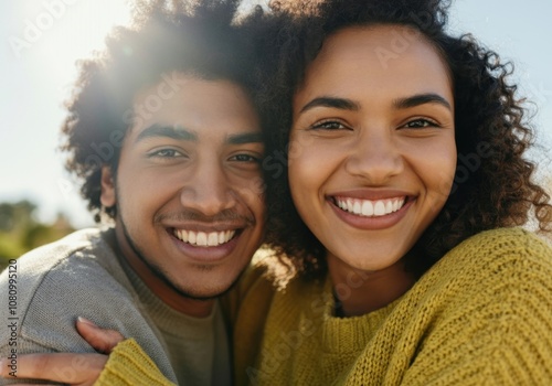 Happy multi-ethnic couple smiling together outdoors in sunlight