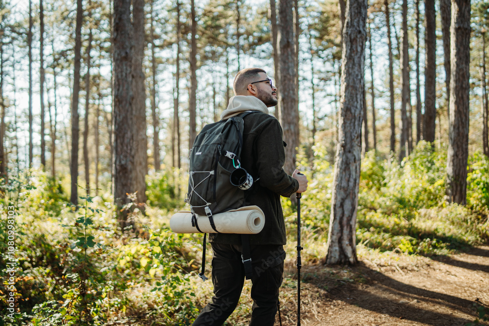 Young caucasian man hiking or trekking through the forest Young caucasian man hiking or trekking through the forest