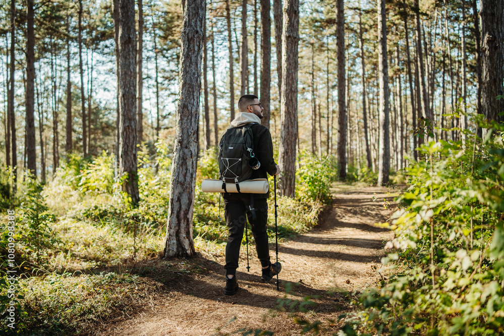 Young caucasian man hiking or trekking through the forest Young caucasian man hiking or trekking through the forest