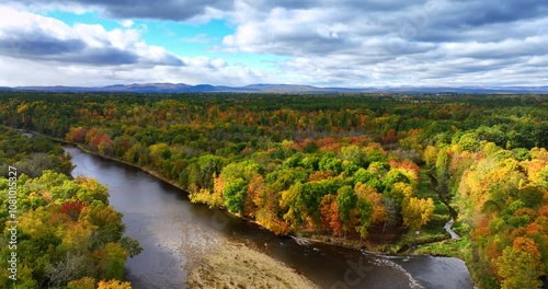 Amazing nature landscape on North New York State in autumn. Beautiful river flows among the colorful woods. Dramatic cloudscape above panorama. photo