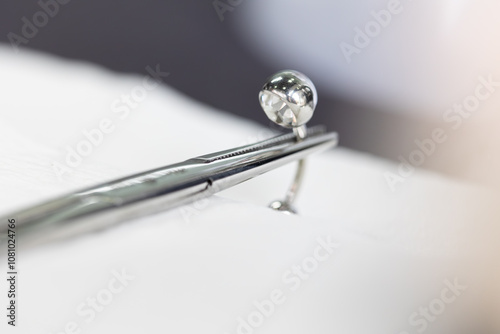 Navel piercing held in place by pliers
