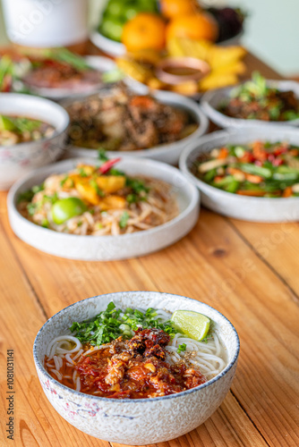 Khao Soi Chiang Tung is served in a bowl with sticky rice noodles and a flavorful soup that is Chiang Tung style. The delicious Khao Soi Chiang Tung is a popular noodle dish among Tai Yai people.