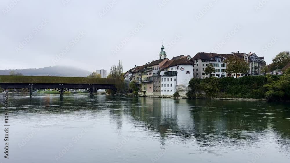 The Covered Historical Wood Bridge Holzbrücke over River Aare and Old Town in Autumn in Olten, Canton Solothurn, Switzerland. The Covered Historical Wood Bridge Holzbrücke over River Aare and Old Town in Autumn in Olten, Canton Solothurn, Switzerland.