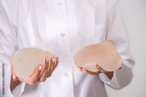 doctor squeezes in his hand breast enlargement implant, plastic surgery, beauty enhancement, medical Mammoplasty and plastic surgery, mastopexy