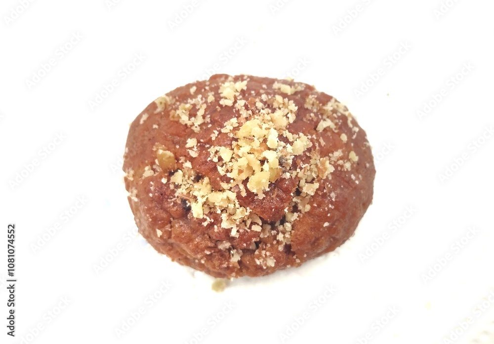 Top view of a Greek melomakarono, a traditional honey-soaked Christmas dessert, topped with crushed walnuts, isolated on a white background. Top view of a Greek melomakarono, a traditional honey-soaked Christmas dessert, topped with crushed walnuts, isolated on a white background.