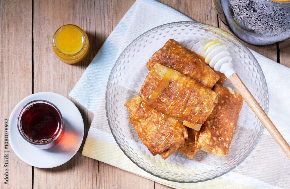 Pancakes with cottage cheese and raisin filling, served with honey and black tea. Traditional treat for Maslenitsa or Carnival.
