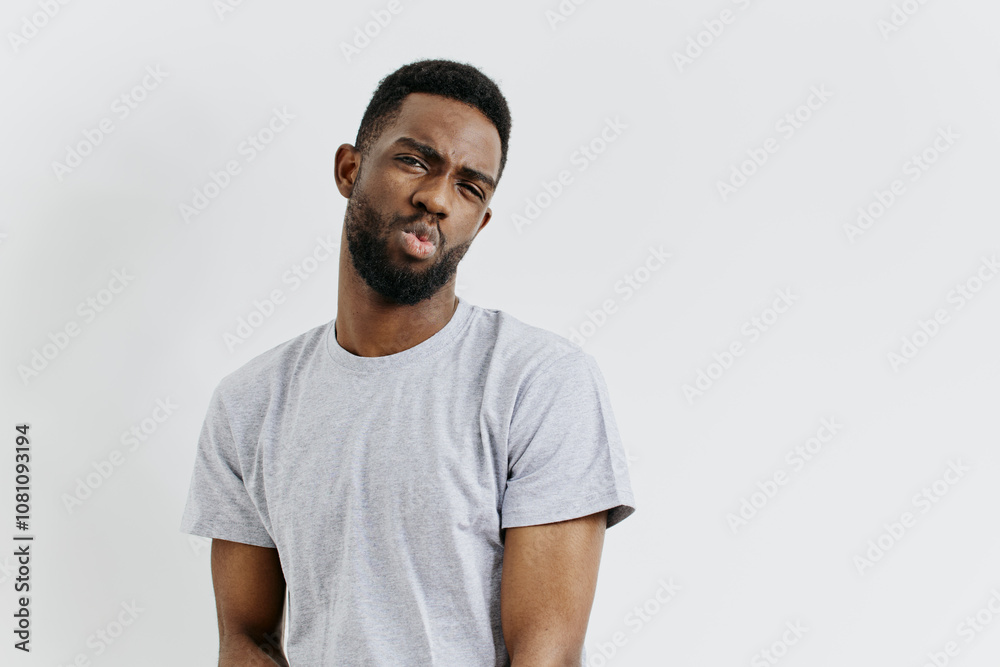 Confident man in grey tshirt stands with hands on hips, exuding determination and readiness for action Confident man in grey tshirt stands with hands on hips, exuding determination and readiness for action