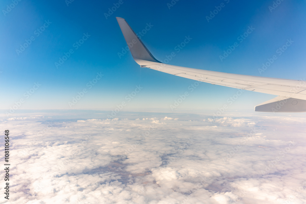 View from the airplane window at a beautiful cloudy sky and the airplane wing View from the airplane window at a beautiful cloudy sky and the airplane wing