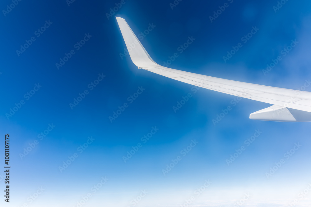 View from the airplane window at a beautiful blue clear sky and the airplane wing View from the airplane window at a beautiful blue clear sky and the airplane wing