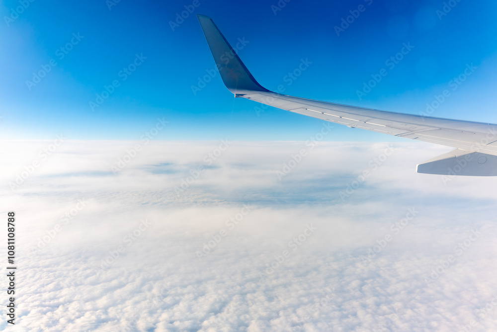 Obraz premium View from the airplane window at a beautiful cloudy sky and the airplane wing
