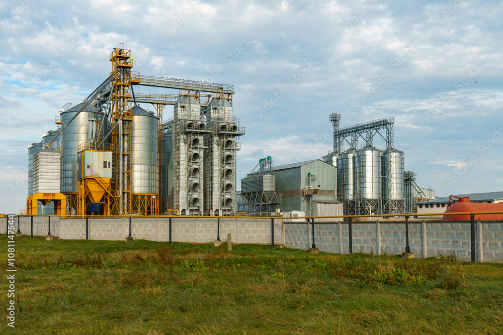 silver silos on agro manufacturing plant for processing drying cleaning and storage of agricultural products, flour, cereals and grain. Large iron barrels of grain. Granary elevator silver silos on agro manufacturing plant for processing drying cleaning and storage of agricultural products, flour, cereals and grain. Large iron barrels of grain. Granary elevator