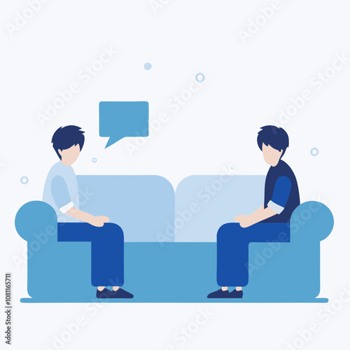 Two men are sitting on a couch, one of them is talking to the other. The couch is blue and the men are wearing blue shirts. Scene is casual and friendly, as the two men are having a conversation