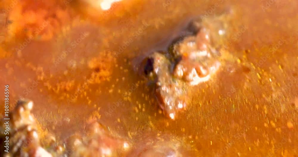 pieces of beef and veal with onions and carrots in tomato sauce are boiling in a saucepan. Festive dinner pieces of beef and veal with onions and carrots in tomato sauce are boiling in a saucepan. Festive dinner