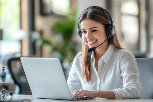 happy call center agent wearing headset talking to client working in customer support office. professional contract service telemarketing operator using laptop having conversation. candid shot
