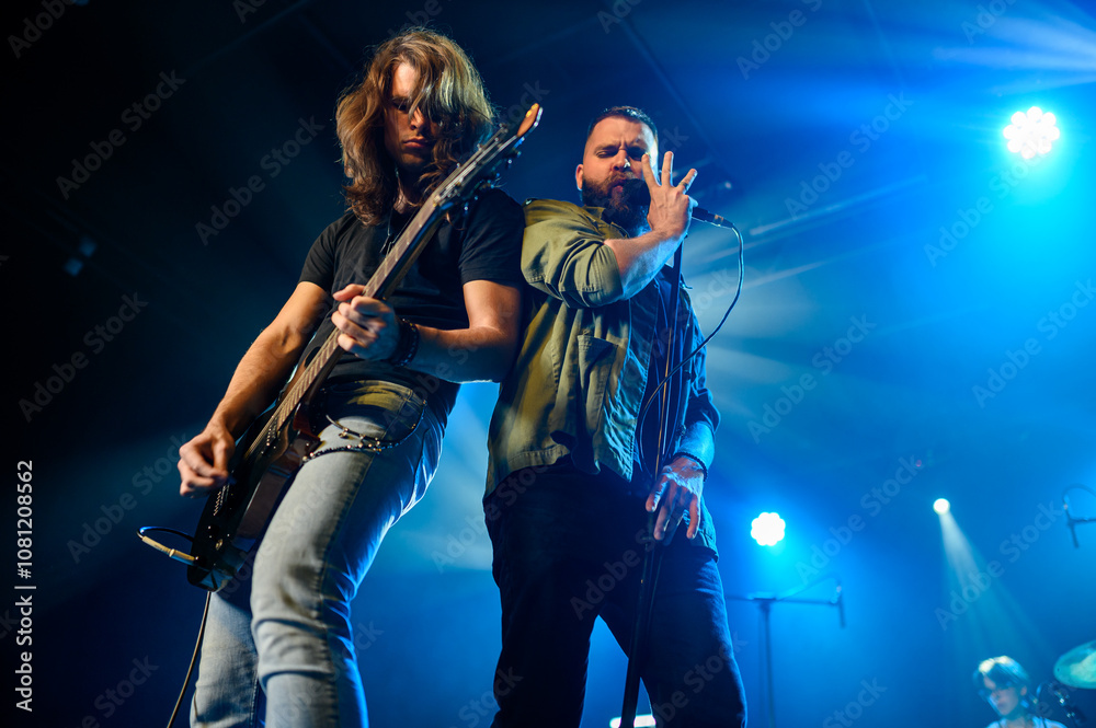 Fototapeta premium Rock band performing live on stage with guitarist and singer