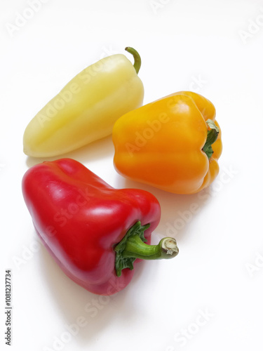 yellow, orange and red peppers on white background