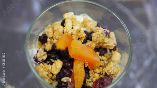 Yogurt with granola, forest fruits and dried apricots