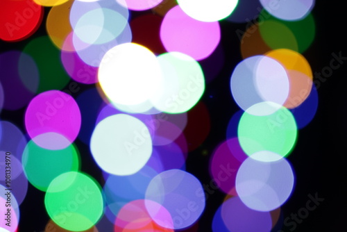 Una toma de cerca de una fondo abstracto de luces de navidad de diferentes colores en la oscuridad. Desenfoque bokeh