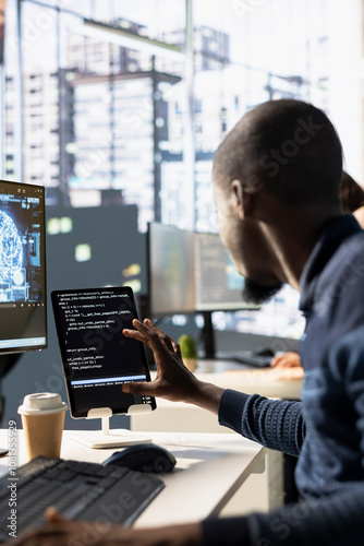 Programmer using tablet, creating AI machine learning models that can process and analyze data to automate decision making processes. IT expert doing artificial intelligence programming using device