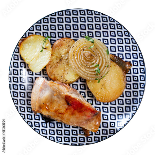 Juicy baked lamb chops accompanied by roasted potatoes and onion slices, topped with fresh herbs and served with side of red sauce for dipping. Isolated over white background