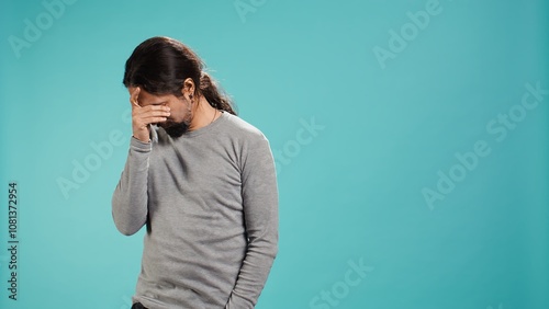 Portrait of troubled man feeling saddened and rattled by bad news, isolated over studio backdrop. Distressed person on the verge of crying, left speechless by troubling events, camera B photo