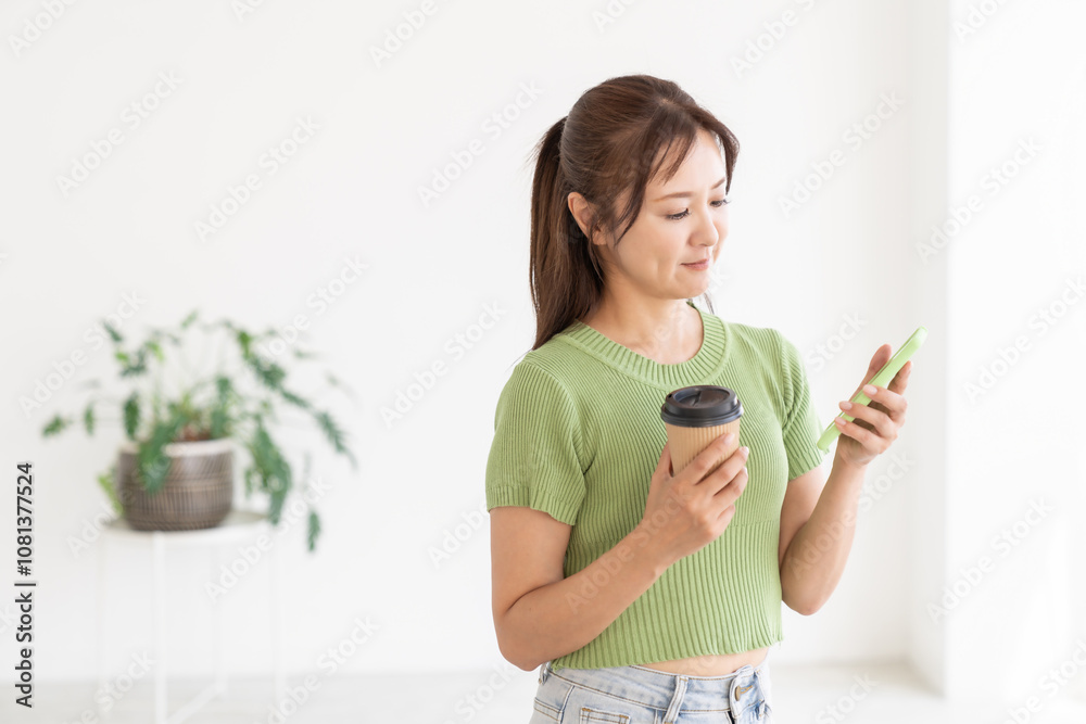 部屋でスマホを見る女性 部屋でスマホを見る女性