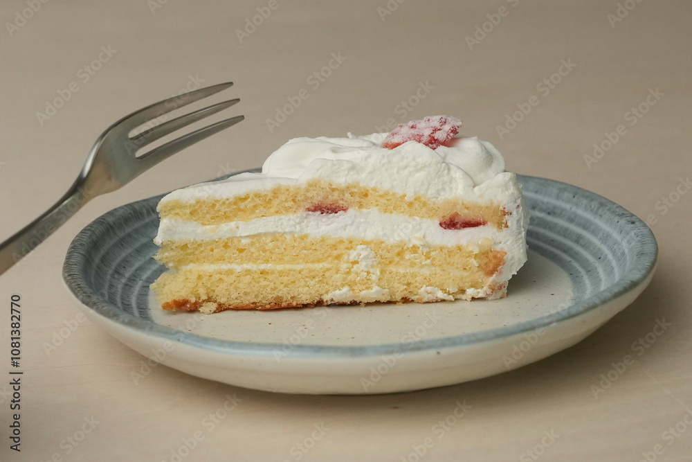 Japanese strawberry shortcake and fork on each stylish large and small plate on a wooden table Japanese strawberry shortcake and fork on each stylish large and small plate on a wooden table